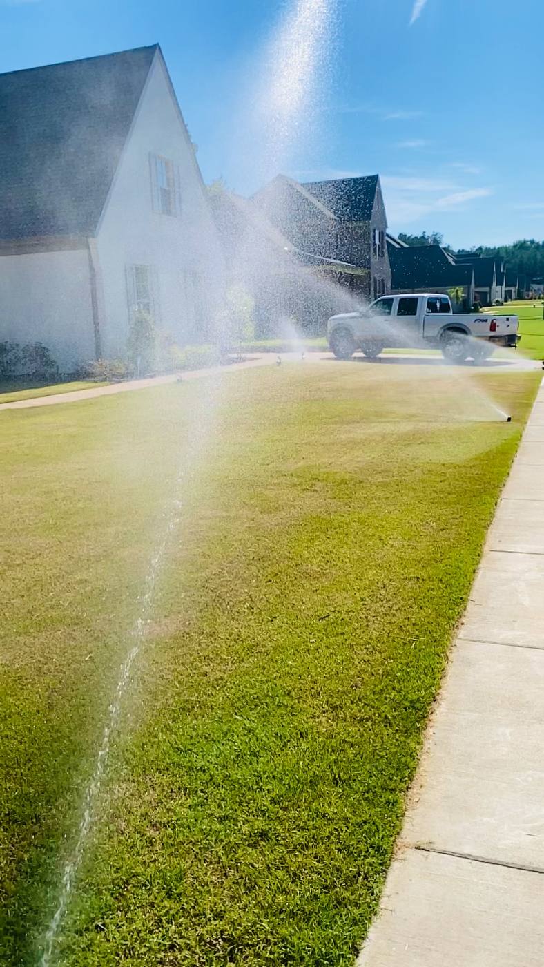 Sprinkler system irrigating a lush green lawn in West Tennessee